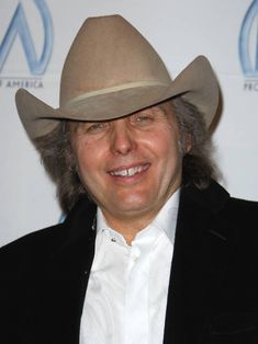 a man wearing a cowboy hat smiling for the camera