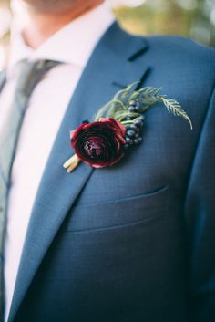 a man in a blue suit with a boutonniere on his lapel