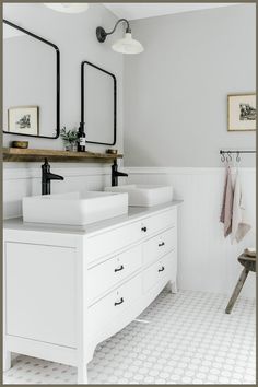 a white bathroom with two sinks and mirrors