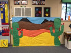 a bulletin board with cactus and mountains on it in an office cubicle decorated for school