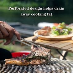 a person cutting food on top of a bbq grill with a knife and fork