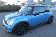 a small blue car parked in a parking lot