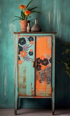 an old cabinet with flowers and vases on top is painted in teal, orange and blue