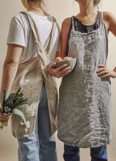 two women standing next to each other with food in their hands and one holding a bowl