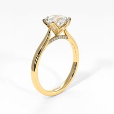 a yellow gold engagement ring with a pear shaped diamond on the center and side stones