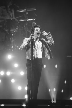 a man standing on top of a stage holding a microphone