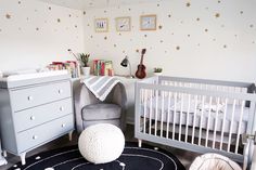 a baby's room with white furniture and stars on the wall