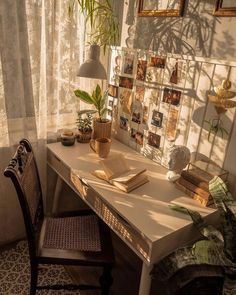 a table with a book and some plants on it in front of a curtained window