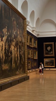 a woman standing next to a large painting in a museum