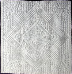 a white quilt with an intricate design on it