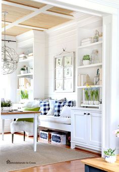 a living room filled with furniture and lots of white shelves on top of each other