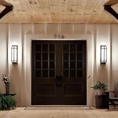 an entry way with two doors and potted plants