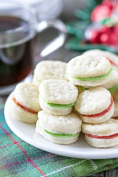 a white plate topped with cookies next to a cup of tea