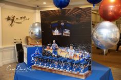 a table topped with balloons and pictures of basketball players on display in front of an audience