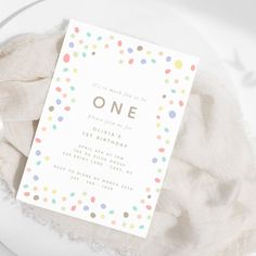 a polka dot birthday party card on top of a white plate with some napkins