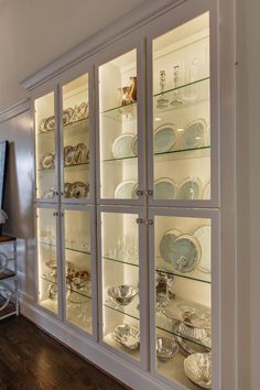 an empty china cabinet with glass doors and plates