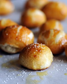 small rolls with sesame seeds on them sitting on a baking sheet, ready to be baked