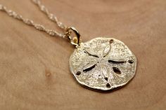 Thank you for taking a look at this beautiful gold Sand Dollar Necklace in a nice medium size. This is a great gift for a beach lover and everyone that likes the ocean and seashells.  Lots of realistic details on this sand Dollar Necklace. The Necklace option with the sand dollar and a with a 14kt. gold filled 18" long 1.5mm. wide loose rope chain. The charm option is for a charm bracelet. The size of the Sand Dollar is 3/4" tall by 3/4" wide. This item is made in 14kt Gold Vermeil Vermeil is a Elegant Starfish Jewelry For Vacation, Elegant Starfish Shaped Jewelry For Vacation, Gold Strand Charm Necklace As Gift, Gold Strand Charm Necklace For Gift, Beachy Starfish Jewelry Gift, Gold Strand Jewelry For Gift, Beachy Gold Jewelry For Vacation, Beachy Starfish Charm Jewelry For Gifts, 14k Gold Filled Shell Shaped Jewelry Gift