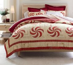 a bed with red and white comforters in a bedroom