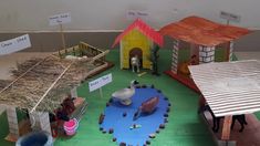 a paper model of a farm with animals and people