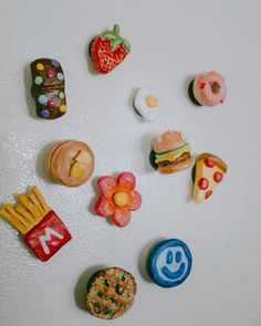 there are many miniature food items on the refrigerator door magnets that look like they were made out of candy