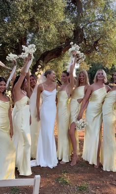 a group of women in white dresses posing for a photo