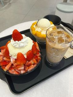 there is a tray with strawberries, ice cream and oranges on it next to a drink