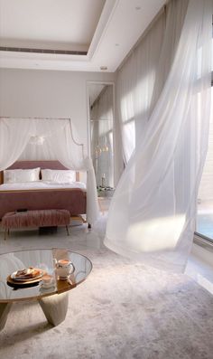 a bed room with a glass table and a large window