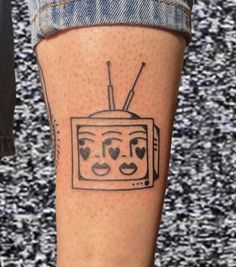 a tattoo on the leg of a person with a tv and hearts drawn on it