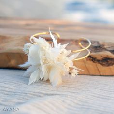 a white flower sitting on top of a piece of wood