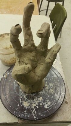 a clay hand sitting on top of a plate