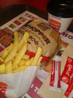 french fries and chips on a tray next to a drink