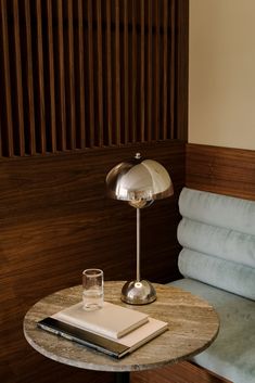 a table with a book and a glass on it next to a couch in a room