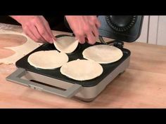 someone is making pancakes on a griddle in the kitchen