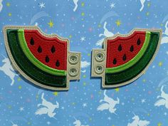 two pieces of watermelon on a blue background with white stars and unicorns