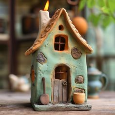 a clay house with a candle in the window