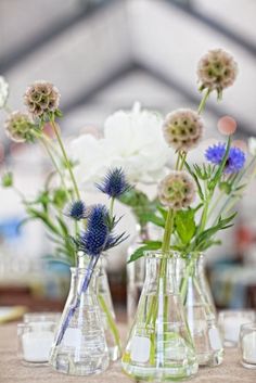 three vases filled with flowers on top of a table