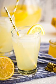 two glasses filled with lemonade sitting on top of a blue and white striped towel