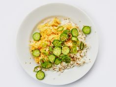 a white plate topped with rice and cucumbers