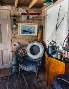 an old chair with a hat on it in front of a wooden paneled wall