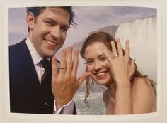 a man and woman posing for a picture with their hands in front of the camera