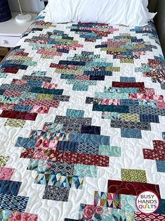 a bed with a large quilt on top of it