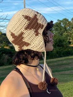 a woman wearing a brown and white crocheted hat