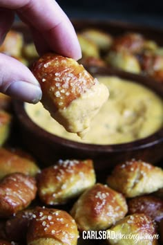 a person dipping some food into a bowl