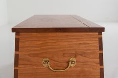 a wooden box with brass handles on a white background