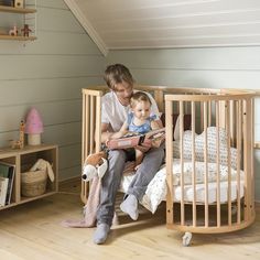 a man sitting in a crib reading to a child