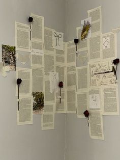 an open book with many pages cut out and pinned to the wall next to it