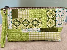 a green and white patchwork purse sitting on top of a table