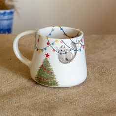 a coffee mug with a christmas tree and squirrel on it