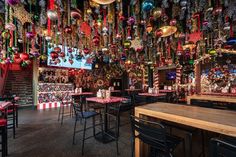 the interior of a restaurant decorated for christmas with ornaments hanging from the ceiling and tables